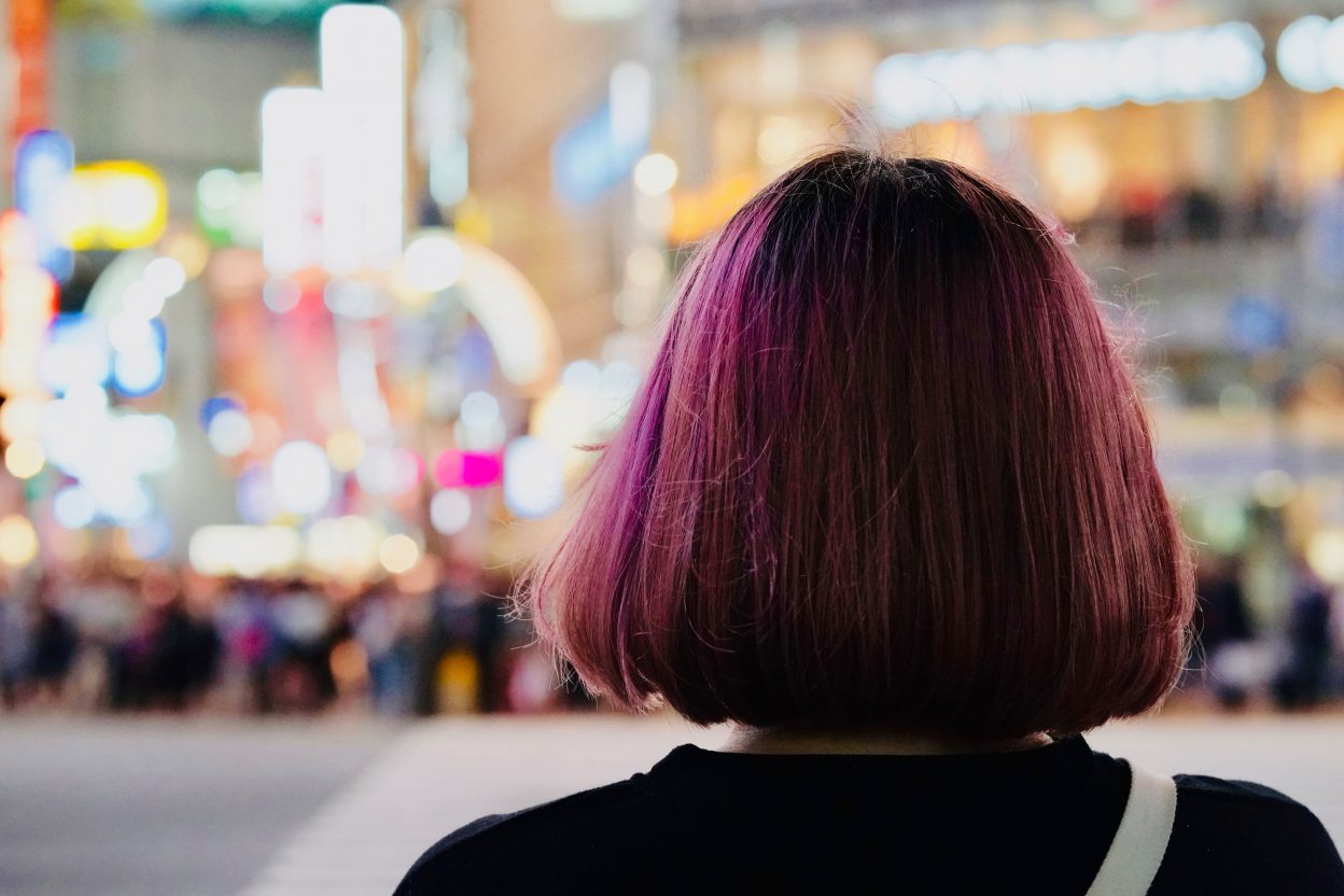 purple apple-cut haired woman facing at the back